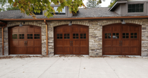 Wooden arched garage doors on a stone exterior.