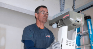 Technician fixing a garage door opener.