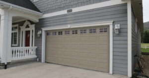 Modern beige garage door on grey house.