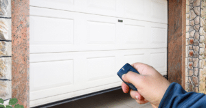 Hand holding remote, opening garage door.