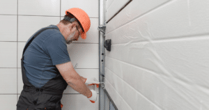 Worker repairing a white garage door